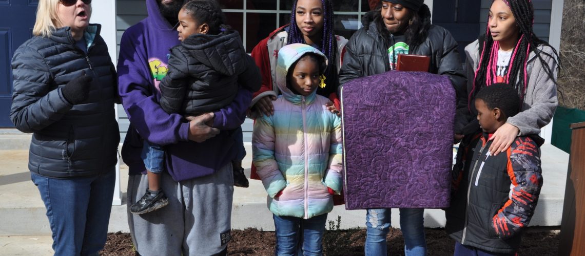 Habitat Board Member Debbie Frazier (left) speaks at dedication of Habitat home of Brandon and Lakeitshia Allen.